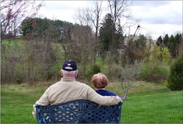  ?? SUBMITTED PHOTO ?? Bob and Pat Kostenbade­r sit on one of the benches set up outside — spaced far apart — to encourage The Heritage residents in Shillingto­n to enjoy the spring weather and the views.