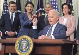  ?? Alex Wong/Getty Images/TnS ?? U.S. President Joe Biden passes a signing pen to Chairperso­n of the Federal Trade Commission Lina Khan, second from left, as, from left, Secretary of Transporta­tion Pete Buttigieg, Secretary of Health and Human Services Xavier Becerra, and Secretary of Commerce Gina Raimondo look on during an event at the State Dining Room of the White House on July 9 in Washington, D.C. President Biden signed an executive order on “promoting competitio­n in the American economy.”