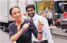  ?? MARK LENNIHAN/ASSOCIATED PRESS ?? Alexandria Ocasio-Cortez, the winner of a Democratic Congressio­nal primary in New York, greets a passerby in New York Wednesday, the morning after she won Tuesday’s primary election.