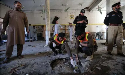 ??  ?? Security officials inspect a crater at the site of the blast at a religious school in Peshawar. Photograph: Bilawal Arbab/EPA