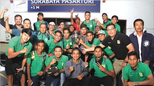  ?? ALLEX QOMARULLA/JAWA POS. ?? OLEH-OLEH GELAR: Para pemain, pelatih, dan ofisial Persebaya berpose bersama trofi Dirgantara Cup di Stasiun Pasar Turi, Surabaya, tadi malam (13/3).