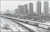  ?? PHOTOS BY ZHENG XINQIA / NANFANG DAILY PROVIDED TO CHINA DAILY ?? From left: Vehicles are stuck in a traffic jam on the Beijing-Hong Kong-Macao Expressway on Monday. A screen at Wuchang Railway Station in Wuhan displays train delays on Monday. Workers deliver instant noodles and hot water to drivers trapped on a highway in Wuhan. A tractor is used to clear ice and snow along a highway in Anhui.