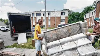  ?? CHRIS STEWART
/ STAFF ?? Michael Smith (right) gets help moving out of his home of 17 years at Western Manor Apartments. Wanisha Smith has been indicted for involuntar­y manslaught­er for allegedly leaving her son Darius Hall Jr. to die there.