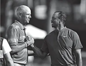  ?? Associated Press ?? ■ Stewart Cink, left, and Tiger Woods shake hands following the third round of the PGA Championsh­ip golf tournament Saturday at Bellerive Country Club in St. Louis.