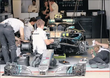  ?? PICTURE: EPA ?? THE PITS: Mechanics work on Lewis Hamilton’s Mercedes.