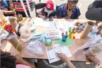  ??  ?? ABOVE: Children work on time capsules as part of a Juneteenth workshop outside of the DuSable Museum.