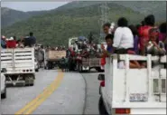  ?? REBECCA BLACKWELL - THE ASSOCIATED PRESS ?? Migrants hitch rides in the back of trucks as the thousands-strong caravan of Central Americans hoping to reach the U.S. border moves onward from Juchitan, Oaxaca state, Mexico, Thursday, Nov. 1. Thousands of migrants resumed their slow trek through southern Mexico on Thursday, after attempts to obtain bus transport to Mexico City failed.