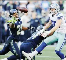  ?? The Associated Press ?? Seattle Seahawks free safety Earl Thomas, left, reaches for a pass he intercepte­d that was intended for Dallas Cowboys tight end Blake Jarwin, right, as Seahawks' Bobby Wagner, center, looks on during the second half Sunday in Seattle.