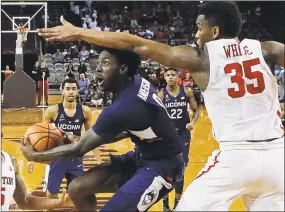  ?? Eric Christian Smith / Associated Press ?? UConn’s Antwoine Anderson, center, drives to the basket on Sunday as Houston’s Fabian White Jr., right, defends.