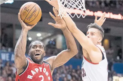  ?? JONATHAN HAYWARD THE CANADIAN PRESS ?? Raptors forward Kawhi Leonard, battling with Trail Blazers forward Zach Collins, had 12 points in the Raptors’ exhibition opener.