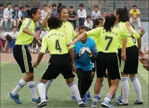  ?? LIU JING / CHINA DAILY ?? Players of the Hotan No 4 Middle School girls’ soccer team celebrate a goal. The all-girl team was the first of its kind in Hotan prefecture.