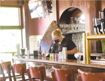  ??  ?? Kristie Bull makes drinks and serves customers during lunch at Two Rivers Brewing in Easton. The restaurant recently held a job fair, hoping to fill open positions during a pandemic labor shortage.