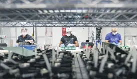  ?? (AP PHOTO/CARLOS OSORIO, FILE) ?? In this May 13, 2020, file photo, Ford Motor Co., line workers put together ventilator­s that the automaker is assembling at the Ford Rawsonvill­e plant in Ypsilanti Township, Mich.