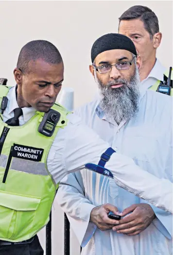  ??  ?? Anjem Choudary appears outside his probation hostel in north London yesterday after being released from prison under police escort