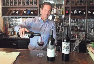  ?? ANNE SCHAMBERG ?? Frank LaSusa of Corvina Wine Company in West Allis pours a flight of Austrian reds last year. This year, along with outdoor seating, Corvina is conducting virtual tastings.