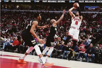  ?? Nam Y. Huh / Associated Press ?? Chicago Bulls guard Zach LaVine shoots against Milwaukee Bucks guard Jevon Carter and forward Giannis Antetokoun­mpo in a first-round NBA playoff game on April 22 in Chicago.