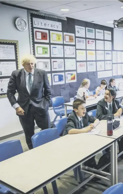  ??  ?? 0 Wearing the school tie he was presented with on arrival, Prime Minister Boris Johnson speaks to a class on their first day back at school during a visit to Castle Rock school in Coalville, East Midlands