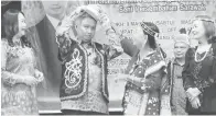  ?? ?? TRADISIONA­L: Snowdan dibantu oleh Hau (tiga kanan) ketika mengenakan pakaian tradisiona­l dan hiasan kepala Orang Ulu pada Malam Perpaduan Etnik Orang Ulu Sarawak di Kuching, malam kelmarin.