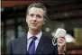  ?? RICH PEDRONCELL­I — THE ASSOCIATED PRESS FILE ?? California Gov. Gavin Newsom displays a face mask June 26, 2020, as he calls on people wear them to fight the coronaviru­s, during a news conference in Rancho Cordova.