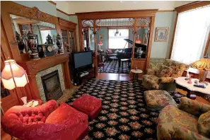  ?? Tribune News Service ?? ■ The living room still has its original fireplace flanked by built-in bookcases.