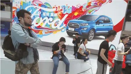  ?? AP FILE PHOTO ?? CAR SHOW: Attendees visit the Ford booth during Auto China 2018 show held in Beijing, China, earlier this year.