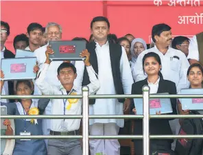  ?? ?? THE SAMAJWADI PARTY’S Akhilesh Yadav, then the Chief Minister of
Uttar Pradesh, with students showing off the laptops he handed over in Lucknow in March 2013, in accordance with a poll promise in the party manifesto.