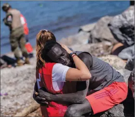  ?? (File Photo/AP/Bernat Armangue) ?? A migrant is comforted by a member of the Spanish Red Cross on May 18 at the Spanish enclave of Ceuta near the border of Morocco and Spain.