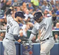  ?? GETTY IMAGES ?? Ryan Braun congratula­tes Jonathan Villar on his solo home run in the sixth inning against the Blue Jays.