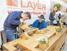  ?? FOTO: ANNETTE RÖSLER ?? Beim Maskenschn­itzen braucht es Konzentrat­ion: Der bekannte Künstler Jogi Weiß (Mitte) gibt Tipps.