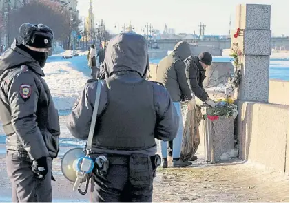  ?? AP ?? Homenajes. Operarios de San Petersburg­o retiran flores colocadas por opositores en un memorial.