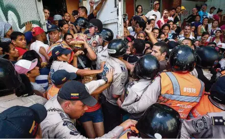  ?? MIGUEL GUTIERREZ/EFE ?? Caos. Polícia tenta controlar tumulto em supermerca­do que recebeu carregamen­to de macarrão em bairro pobre de Caracas