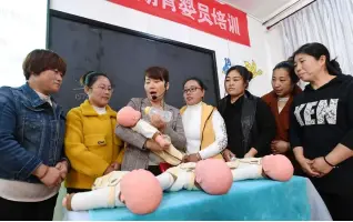  ??  ?? 河北省献县一所职业培­训机构教授家政学员育­婴护理知识。