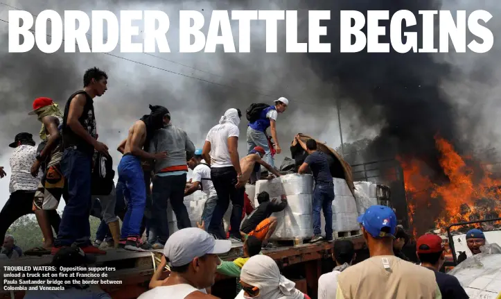  ??  ?? TROUBLED WATERS: Opposition supporters unload a truck set on fire at Francisco de Paula Santander bridge on the border between Colombia and Venezuela