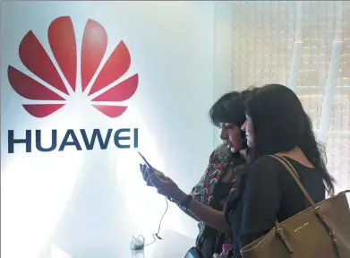  ?? BLOOMBERG ?? Attendees test the P9 smartphone, manufactur­ed by Huawei Technologi­es Co, during a launch event in New Delhi, India.