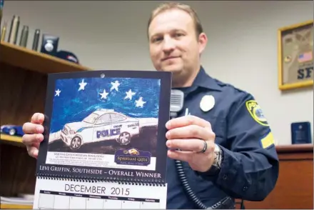  ?? ANGELA SPENCER/THREE RIVERS EDITION ?? Sgt. Keith Graham, Cabot Police Department public informatio­n officer, holds the 2015 C.O.P.S. Toy Patrol Calendar, which features artwork from area students.