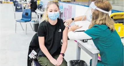  ?? BOB TYMCZYSZYN TORSTAR ?? Allison Stapleton receives her shot as the vaccinatio­n clinic for health-care workers at Seymour-hannah Sports and Entertainm­ent Centre in St. Catharines Wednesday.