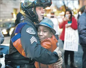  ?? Johnny Huu Nguyen Associated Press ?? DEVONTE HART hugs police Sgt. Bret Barnum in 2014 at a Portland, Ore., rally in support of protests in Ferguson, Mo. The Harts may have left Oregon to avoid media attention after the photo went viral.