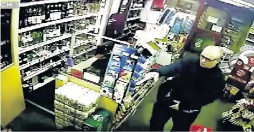  ??  ?? ●●A CCTV image of Michael Harkins as he uses a pellet gun to rob the Bargain Booze shop on Bents Lane in Bredbury