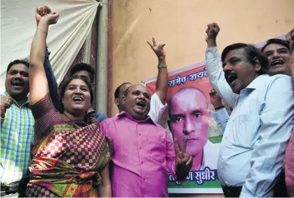  ?? Punit Paranipe / AFP ?? Friends of Kulbhushan Jadhav in a Mumbai neighbourh­ood react after the UN’s highest court yesterday prevented Pakistan from sending the former Indian navy officer to the gallows. A Pakistani military court has found Jadhav guilty of espionage.
