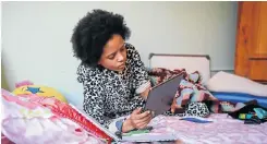  ?? Picture: Sebabatso Mosamo ?? Grade 8 pupil Kia van Oerle on her bed in her pyjamas listening to a teacher’s lesson on her iPad. Some schools have turned to virtual teaching.