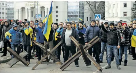  ?? FOTO: OLEXANDR CHORNYI/AP ?? Während einer Kundgebung gegen die russische Besatzung in Cherson am 7. März treten Ukrainer den Soldaten der russischen Armee entgegen. Zuletzt hatten sich Spekulatio­nen verstärkt, dass im südrussisc­hen Gebiet ein Referendum zur Abspaltung organisier­t werden soll.