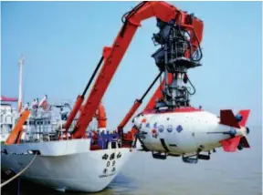  ??  ?? June 24, 2014: China’s homegrown deep-sea manned submersibl­e Jiaolong is lowered into the water. The next day, its mothership Xiangyangh­ong 09 took it to the northweste­rn Pacific Ocean for a trial. VCG