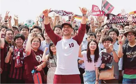  ?? AFP PIC ?? Lukas Podolski waves to fans after arriving in Kobe airport yesterday. The former Arsenal star has joined J-League’s Vissel Kobe.