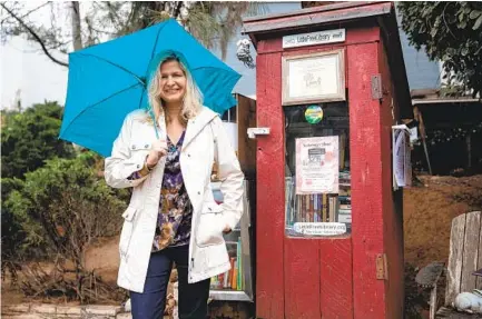  ?? KRISTIAN CARREON ?? Unplug Collaborat­ive co-founder Claudia Erickson next to her Little Free Library outside her La Mesa home. Erickson’s Little Free Library will be the first stop for a scavenger hunt during this weekend’s National Day of Unplugging events.