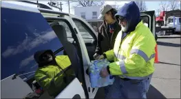  ?? MATT FREED — THE ASSOCIATED PRESS ?? Volunteer Larry Culler helps load water into a car in East Palestine, Ohio, as cleanup from the Feb. 3Norfolk Southern train derailment continues on Friday.