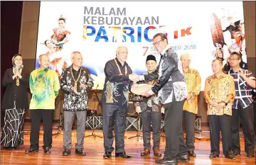  ??  ?? Awang Tengah (left) receives a souvenir from Sulong after officiatin­g at the concert ceremony witnessed by, among others, Manyin (third right) and Maszlee (fourth right). — Photo by Penerangan