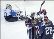  ?? Julio Cortez / AP ?? American women’s hockey teammates celebrate after Dani Cameranesi (24) scores a goal against Finland during the third period of the semifinal round.