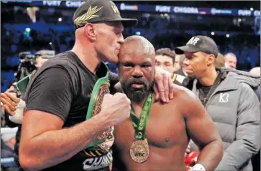  ?? ?? Tyson Fury besa la cabeza de su rival, Derek Chisora, tras derrotarlo ayer en Londres.