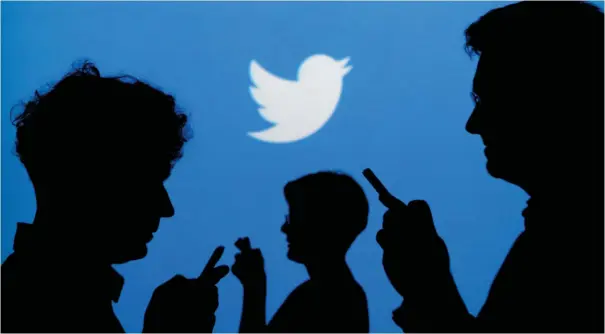  ?? (Kacper Pempel/illustrati­on/Reuters) ?? PEOPLE HOLD cellphones against a backdrop projected with the Twitter logo.