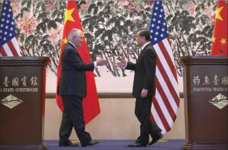  ?? MARK SCHIEFELBE­IN — THE ASSOCIATED PRESS POOL PHOTO ?? Secretary of State Rex Tillerson and Chinese Foreign Minister Wang Yi reach to shake hands Saturday at the end of a joint media conference following their meeting at the Diaoyutai State Guesthouse in Beijing, China. It was Tillerson‘s arrived in...